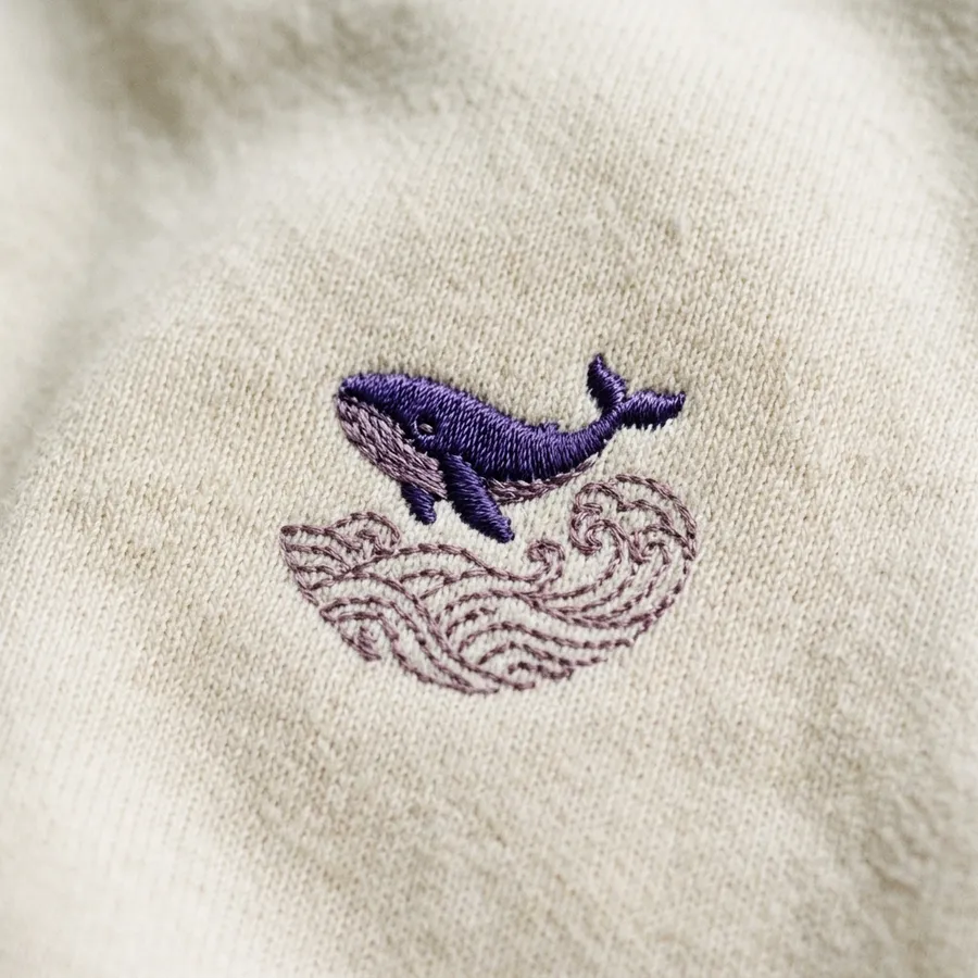 BTS Members Reunite: 'ARIRANG' Comeback & Subtle Merch Fashion A detail shot showing the back neckline of the cream sweatshirt, revealing the word 'ARIRANG' stitched in a beautiful tonal, light cream thread for a sleek, elevated finish.