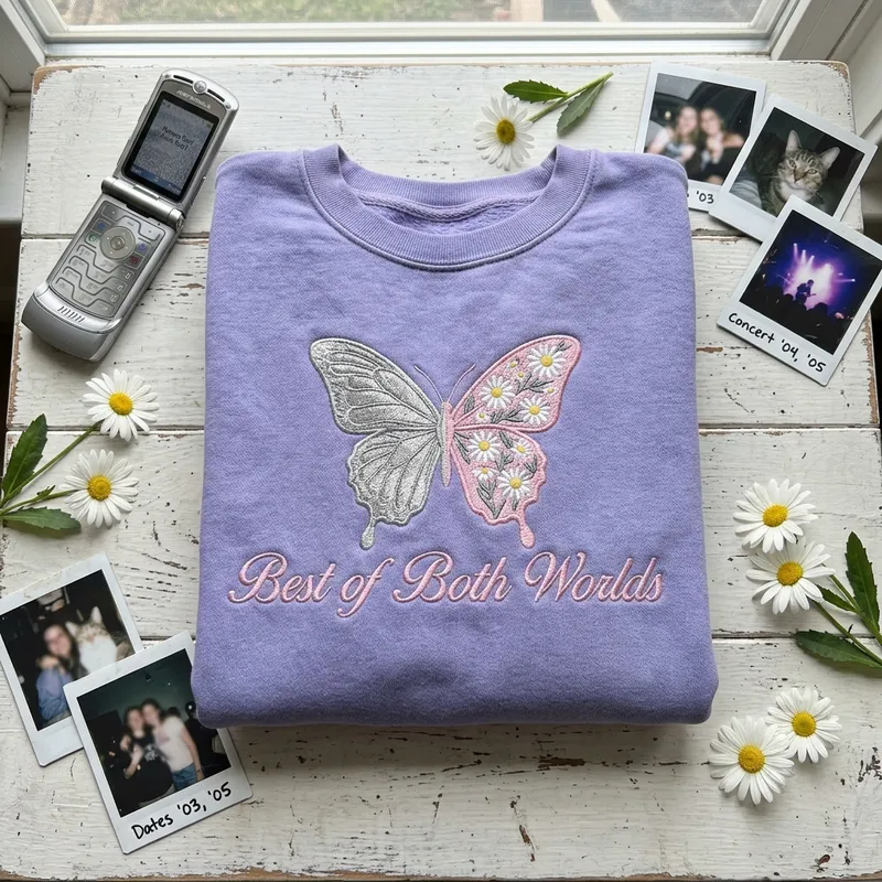 Close-up macro shot showing the intricate embroidery stitch detail of a split butterfly on lavender fabric. One wing features metallic silver and holographic threads, while the other features matte pastel pinks and tiny daisies.