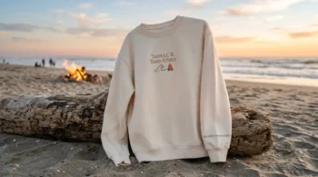 Celebrate the ultimate laguna beach reunion with this cream embroidered sweatshirt draped over beach driftwood.