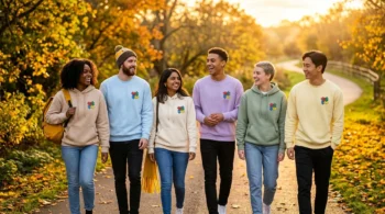 A diverse group of friends wearing cozy embroidered autism awareness sweatshirts walking together in warm sunlight.