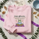 On My Momma Lyrics Embroidered Sweatshirt - Funny Meditating Frog Affirmation MTG 260326 154 AI Mockup 20260326 152206.webp