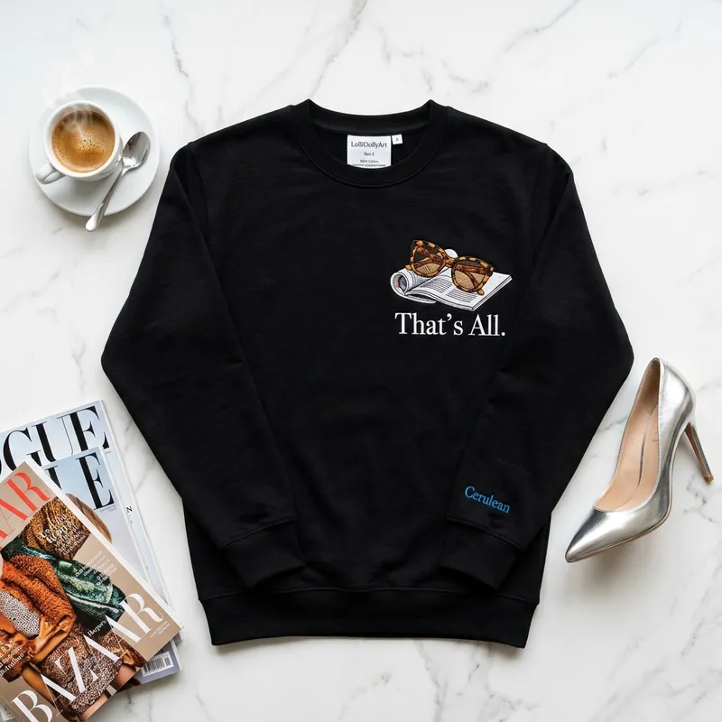 Devil Wears Prada 2 Trend & The "That's All" Embroidered Sweatshirt Close up macro shot of high-density white embroidery showing tortoiseshell sunglasses and the words That's All on a black sweatshirt